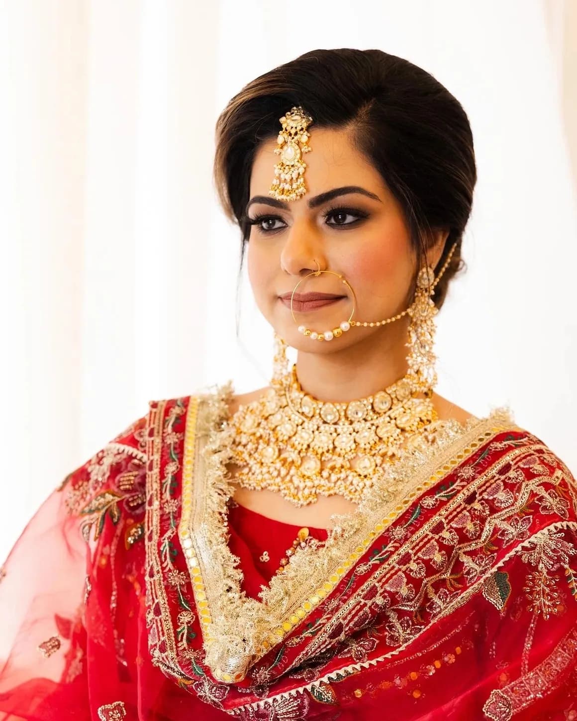 Bridal portrait with layered jewelry and red bridal outfit